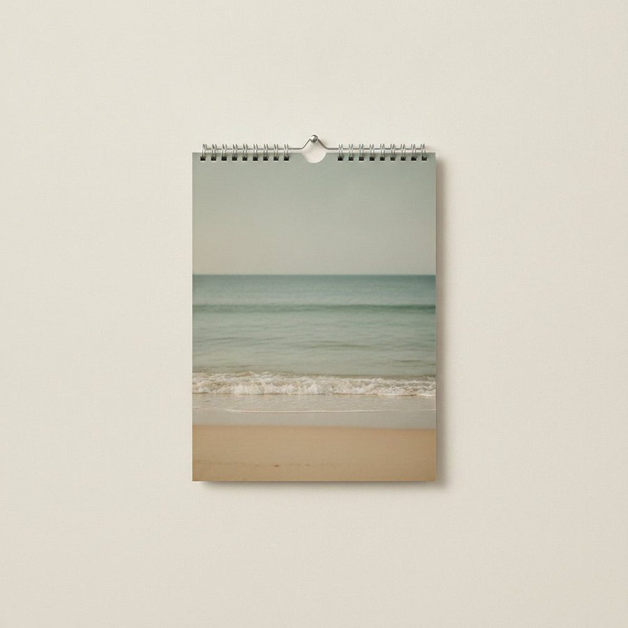 Wandkalender im Format A4 hochkant, Kalenderseite zeigt eine ruhige Strandszene mit Meer und Sand