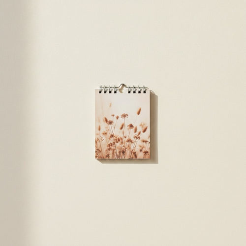 Kompakter Wandkalender im Format A5 hochkant mit einem Trockenblumenmotiv in Terrakotta- und Beigetönen